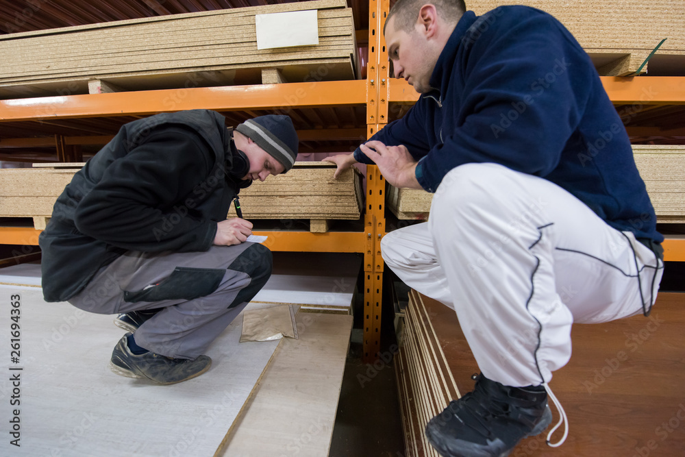 Fototapeta premium two young carpenters writing new prices