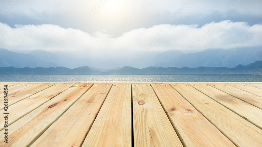 Wooden floor platform and lake with sky background