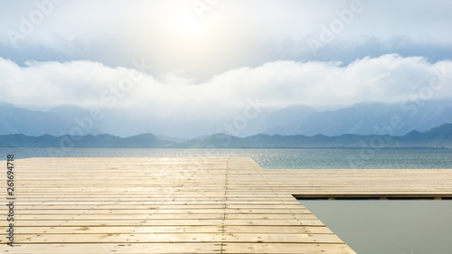 Wooden floor platform and lake with sky background