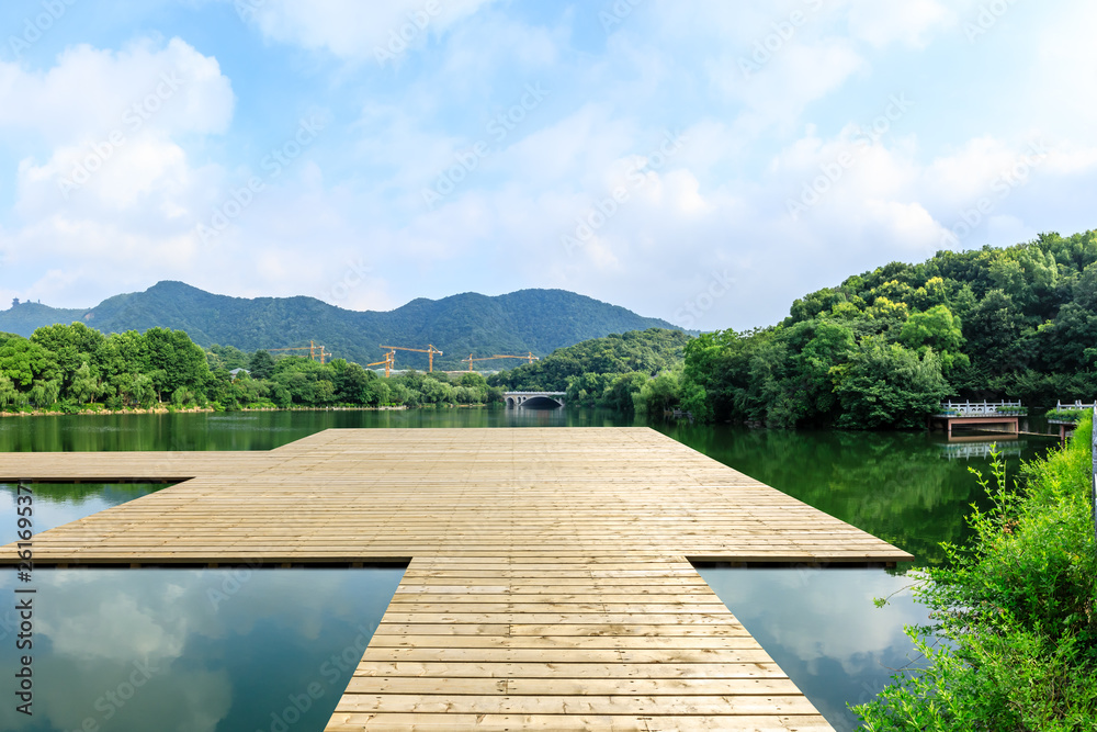 Wooden floor platform and lake with green mountains background in Hangzhou