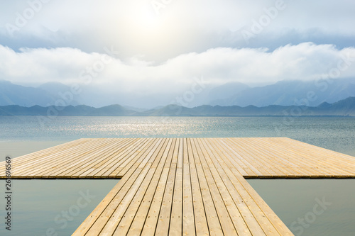 Wooden floor platform and lake with sky background