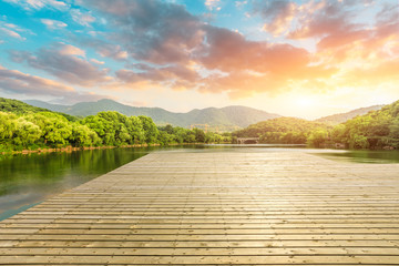 Wooden floor platform and lake with green mountains background in Hangzhou