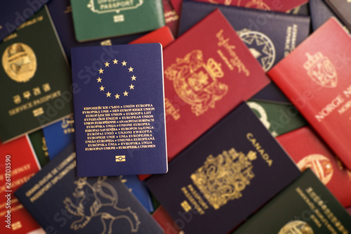 Blue biometric passport of the European Union on a blurred background of mixed passports from around the world photo