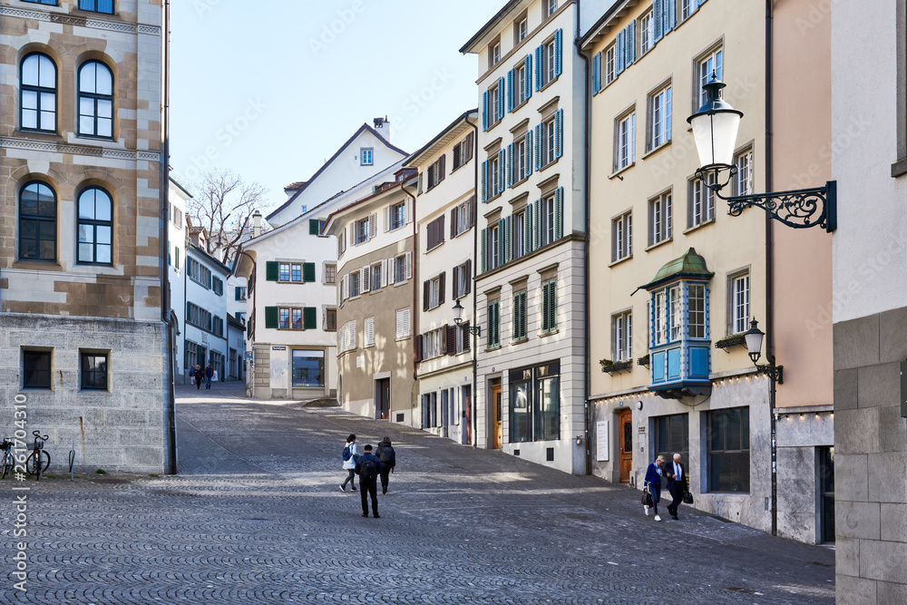 Zürich Kirchgasse, Altstadt, Kopfsteinpflaster, alte Häuser, Erker, alte Strassenlampe, Fussgänger, Architektur