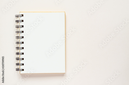 Clean spiral note book for notes and messages on rlight beige background. Minimal business flat lay