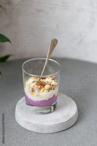 Granola with yogurt, honey and chocolate bars on marble table with copy space