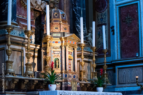 Rich candlesticks on colorful catholic altar © Giorgio G