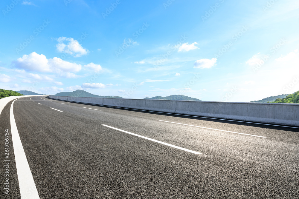 Fototapeta premium Empty asphalt road and mountains with blue sky on a sunny day