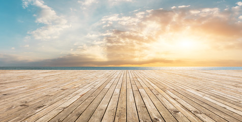 Wooden floor platform and blue sea with sky background