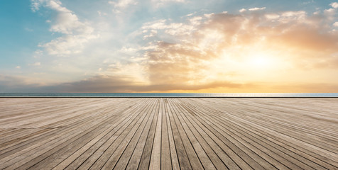 Wooden floor platform and blue sea with sky background