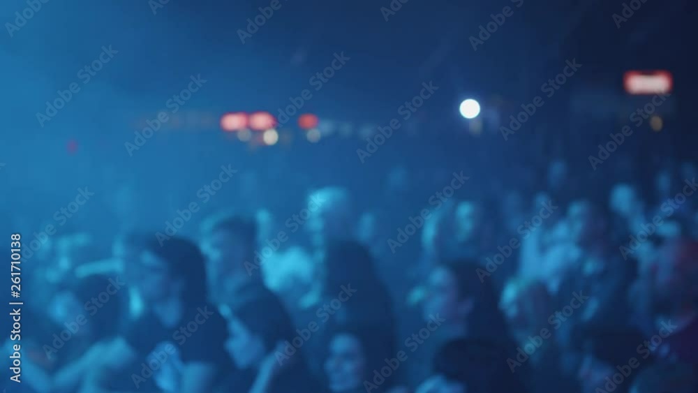 Fans enjoying the performance of their favorite rock band. Audience at a rock concet in front of the stage.