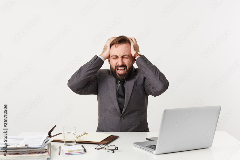 Smartly dressed office worker sitting at table grasping his head,nervous being in a difficult situation, has some work troubles, opened mouth screams from panic,closed his eyes in despair hopelessness Smartly dressed office worker sitting at table grasping his head,nervous being in a difficult situation, has some work troubles, opened mouth screams from panic,closed his eyes in despair hopelessness