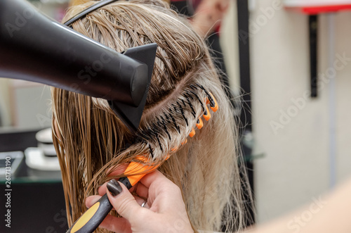Hair styling a hair dryer for a blonde girl