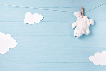 Baby boy background with white teddy bear toy on a clothesline and clouds