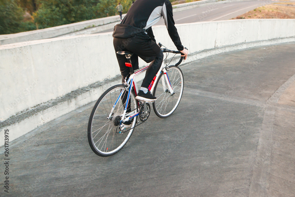 Athlete cyclist in sportswear rides around the city on a white bike. Traveling around the city on a bicycle. Copyspace Athlete cyclist in sportswear rides around the city on a white bike. Traveling around the city on a bicycle. Copyspace