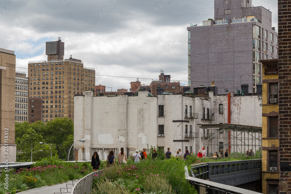 Scene of unidentifiable people walking and enjoying the surroundings and plants on the High Line park located in New York as it winds its way through neighbouring buildings Scene of unidentifiable people walking and enjoying the surroundings and plants on the High Line park located in New York as it winds its way through neighbouring buildings