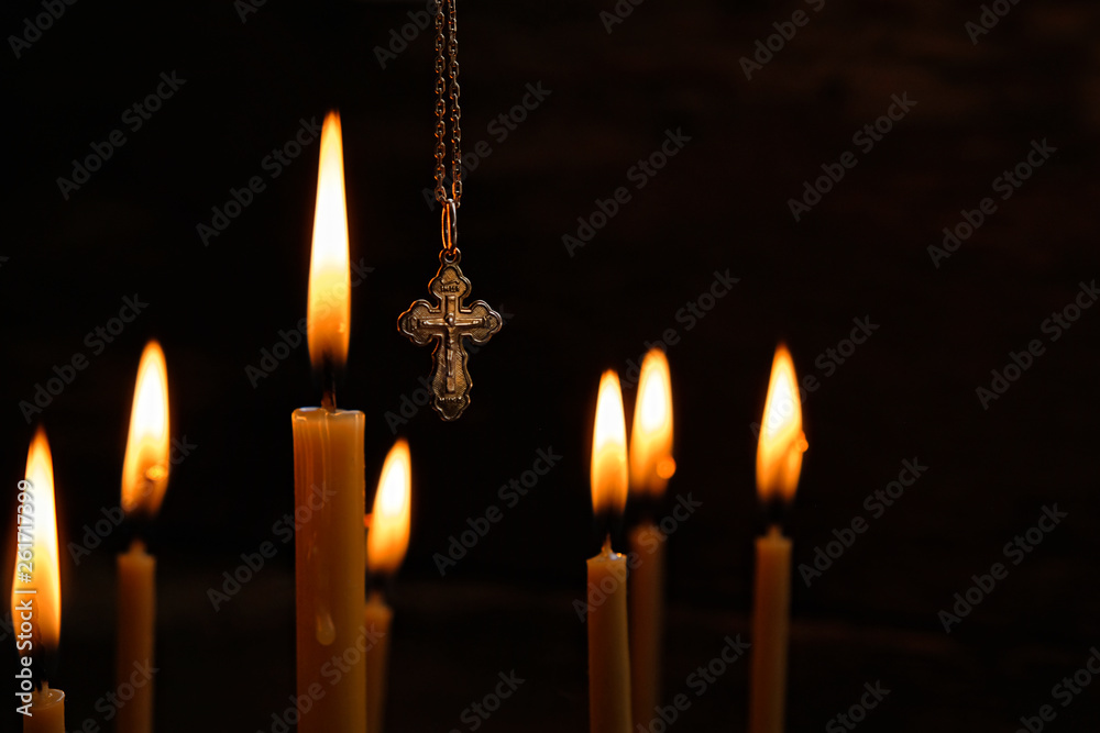 burning Church candle and Orthodox cross on dark background. Easter still life, concept of Orthodoxy and Church. concept of mourning. We Remember, mourn. copy space