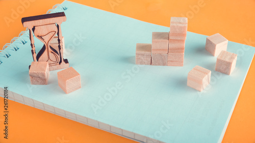 wooden numbers and cubes on a notebook. Concept writing, business plan building, strategic planning, concept management. Yellow-green background, Time flow
