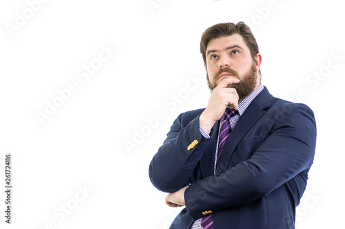 Portrait of a big handsome pensive bearded business man in a dark suit and a bright blue tie, isolated on white