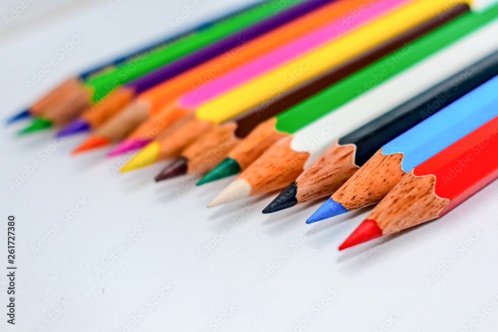 Close-up of a selection of Multi Colored pencils crayons, stick together arranged in a row line bar graph on white background, flat lay. Selective focus, blur image. Back to school creativity concept. Close-up of a selection of Multi Colored pencils crayons, stick together arranged in a row line bar graph on white background, flat lay. Selective focus, blur image. Back to school creativity concept.