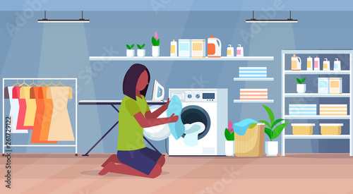 woman putting dirty clothes into washing machine african american housewife doing housework modern laundry room interior cartoon character full length flat horizontal