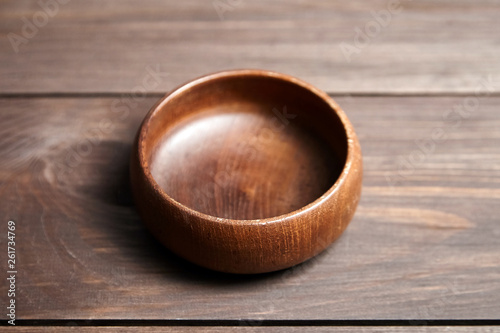 фотографія Empty wooden bowl on brown table
