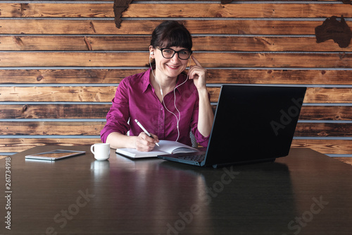 Fotografia, Obraz Smiling businesswoman listening to music at work