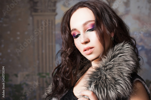 Attractive young brunette woman in stylish fur collar made of eco fur photo