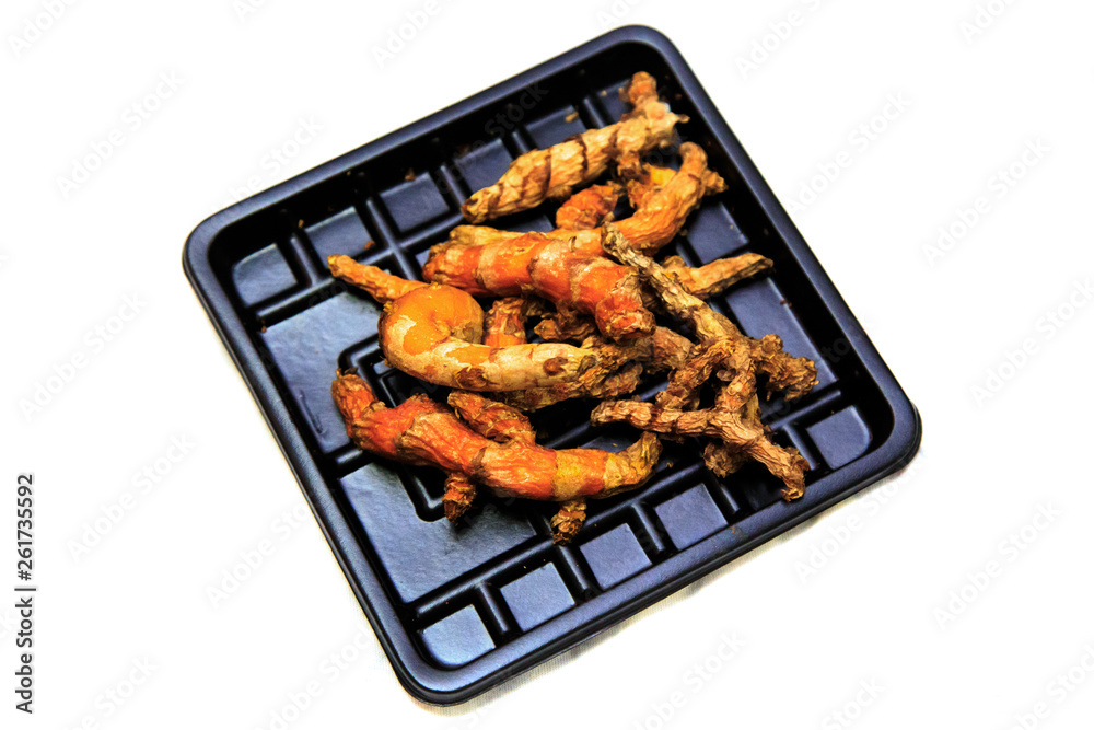 The expired turmeric root on black plastic plate that bought from supermarket The expired turmeric root on black plastic plate that bought from supermarket