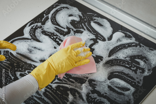 Housewife cleaning an induction plate, closeup shot photo