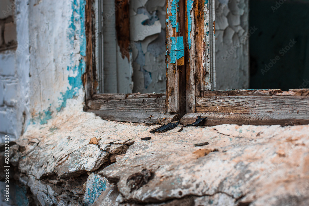 Abandoned building after the fighting. Wooden frame without glass and window sill of a destroyed and old house.