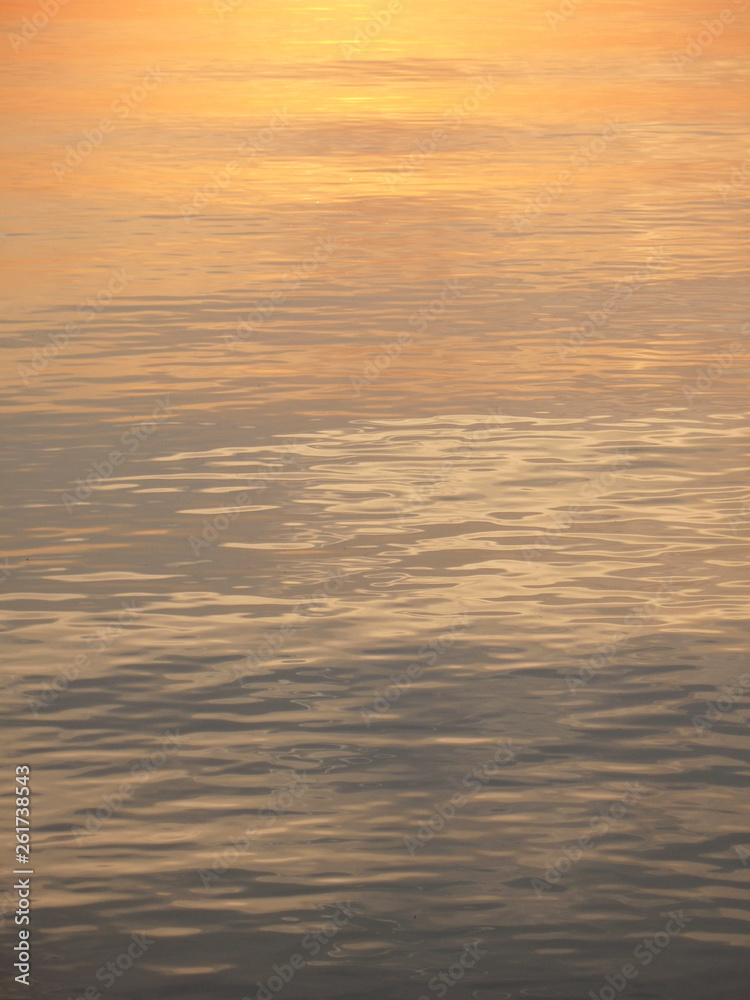 The sun is blurred reflected in the water at sunset. The sun is blurred reflected in the water at sunset.