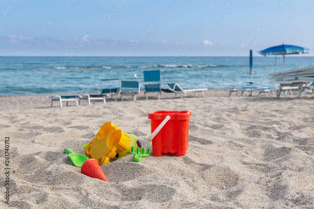 children's toys on the beach sand against turquoise sea. children's toys on the beach sand against turquoise sea.