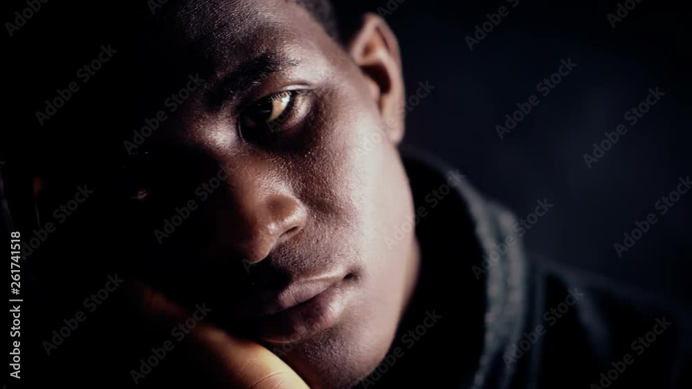 Pensive depressed black african man in the dark.Worries,thoughts Pensive depressed black african man in the dark.Worries,thoughts