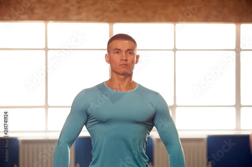 Portrait of Young Strong Man Training in Gym