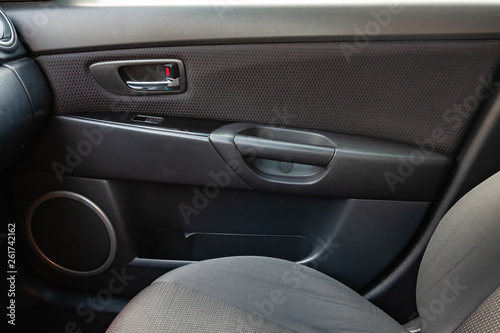 The interior of the car with a view of the dashboard, seats, speaker and door with light gray trim