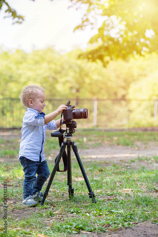 Two years old boy playing with photo camera