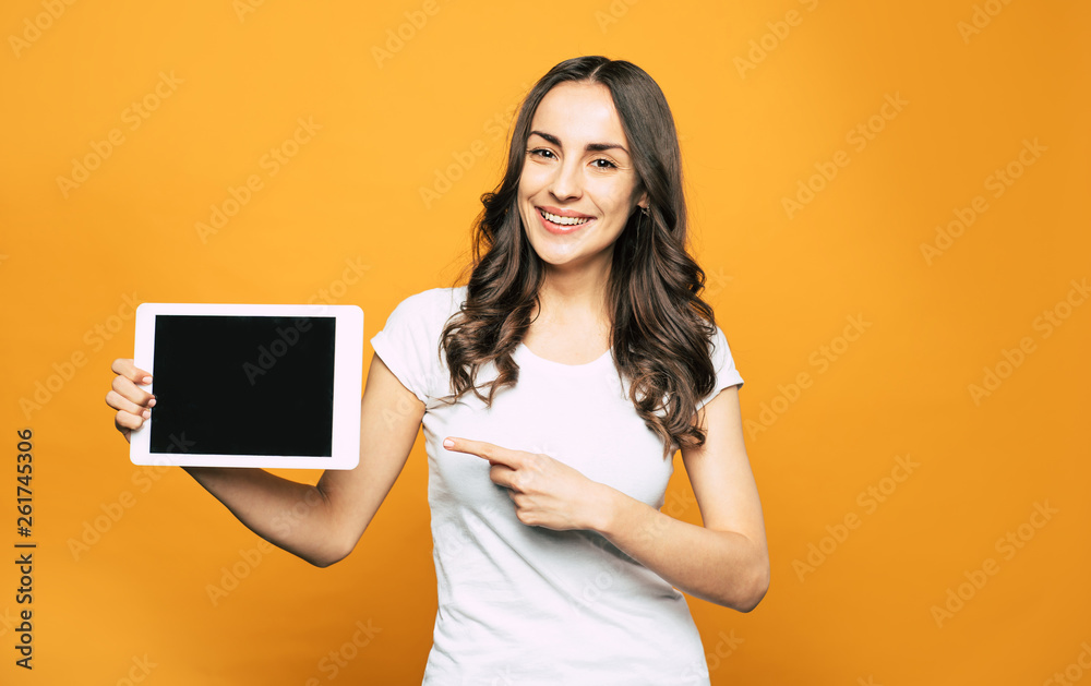 This is what you need! Modern white colored tablet PC with great properties in the hand of gorgeous young girl in basic white T-shirt and brilliant smile all over her face. This is what you need! Modern white colored tablet PC with great properties in the hand of gorgeous young girl in basic white T-shirt and brilliant smile all over her face.