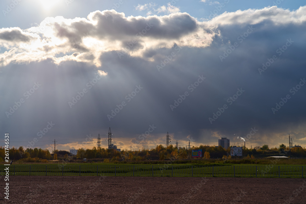 Urban landscape of power lines against the background of sunlight breaking through the clouds