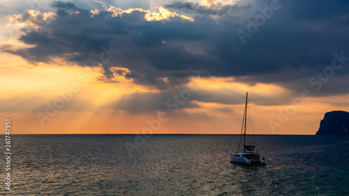 Light of sun pass through clouds with yacht in sea © Krisda