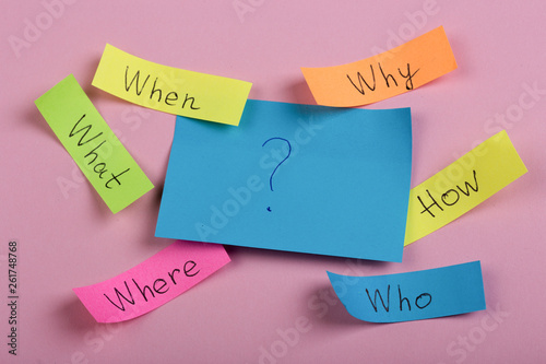 Questions - Why? What? Where? When? Why? How? on colorful stickers on pink backround