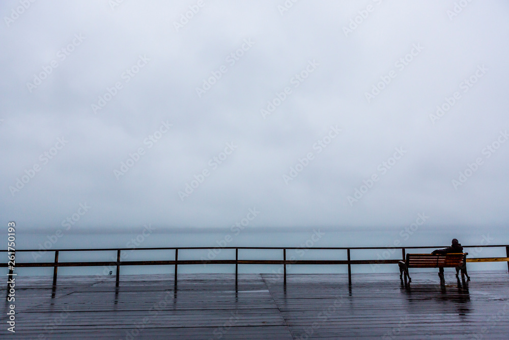 Men sitting on a bench at Barentsburg Harbour on a cloudy Day, Russian territory, Svalbard, Norway
