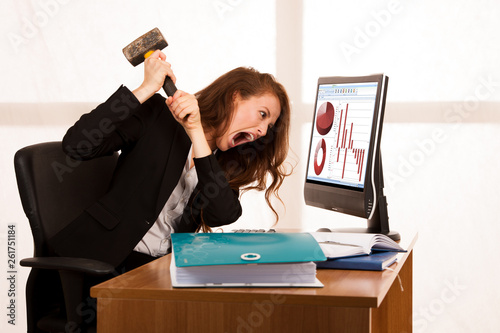 Angry business woman expressing rage at her desk in the office