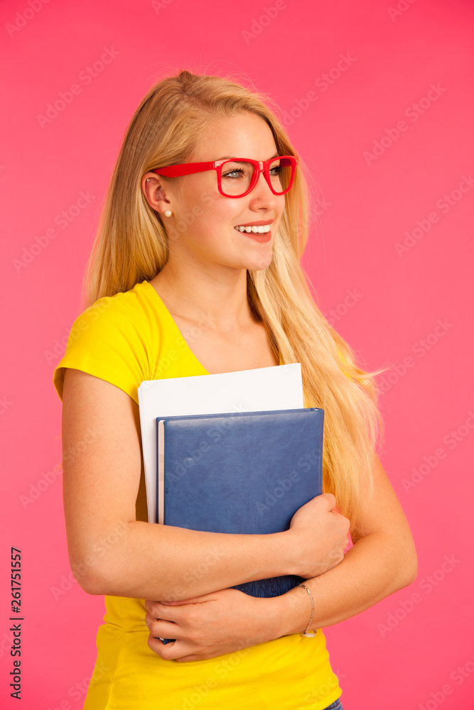 Beautiful young happy woman in yellow t shirt holds folder pose over pink background Beautiful young happy woman in yellow t shirt holds folder pose over pink background
