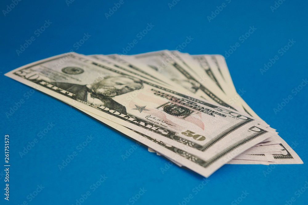 Pack of fifty dollars banknotes isolated on blue background Pack of fifty dollars banknotes isolated on blue background