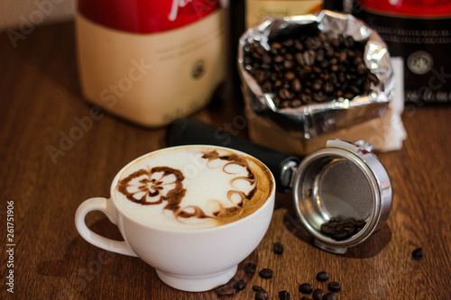 Coffee latte with beautiful design on top, coffee beans background