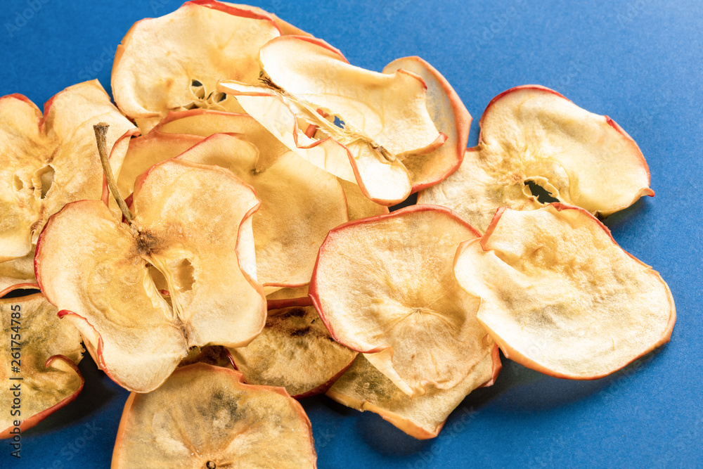 Close-up heap of healthy apple chips on blue background. Close-up heap of healthy apple chips on blue background.