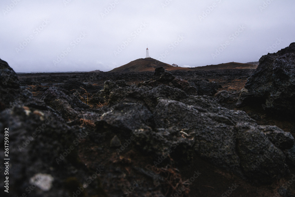 Fototapeta premium Lighthouse on the hill near the coast in Iceland