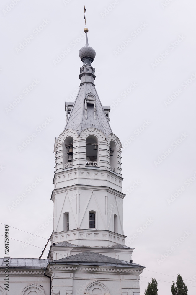 Christian orthodox white church with silver and grey domes with gold crosses. Calm grey sky above Christian orthodox white church with silver and grey domes with gold crosses. Calm grey sky above