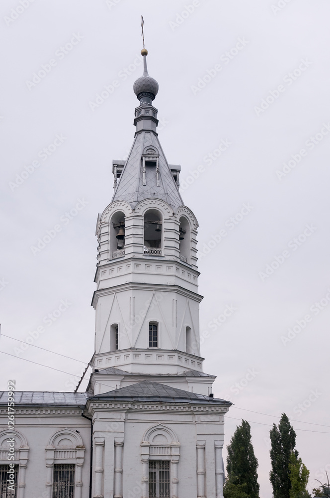 Christian orthodox white church with silver and grey domes with gold crosses. Calm grey sky above